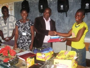 MJ DEM hands over the items to one teen mother in a symbolic ceremony