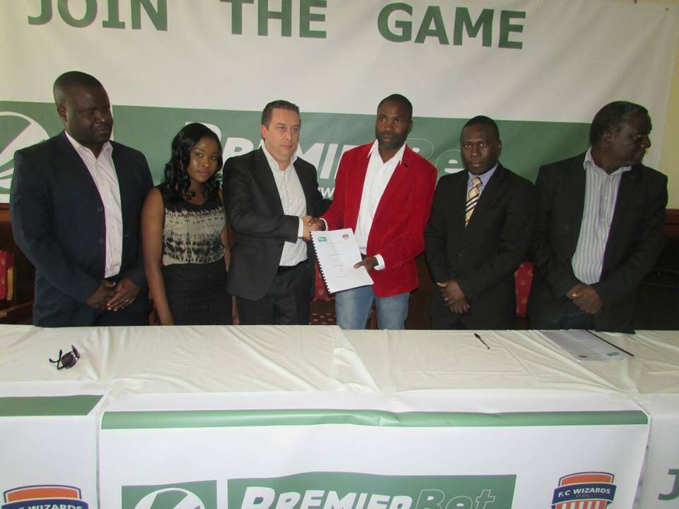 Mponda 9In red jacket) with Premier Bet representatives at the ceremony. 