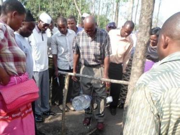 a-community-member-showing-off-a-home-made-hand-washing-facility