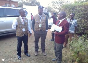 Kachale listening attentively to Neno District Commissioner Blessings Nkhoma in red jacket