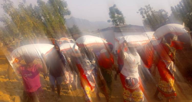 Malawi Congress Party supporters leave a rally carrying maize flour