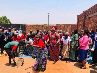 Minister of Gender, Community Development and Social Welfare Jean Sendeza in melon dress during a visit to Mai Mbambande elderly home