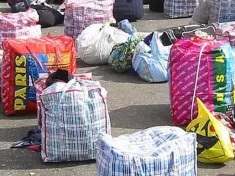 the sack bags got the name Ghana Must Go in the 1980s, when hundreds of thousands of undocumented immigrants, many of whom were Ghanaian, were expelled from Nigeria and they fled with the red-and-blue checked bags on their backs.