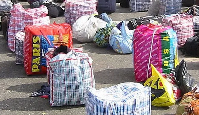 the sack bags got the name Ghana Must Go in the 1980s, when hundreds of thousands of undocumented immigrants, many of whom were Ghanaian, were expelled from Nigeria and they fled with the red-and-blue checked bags on their backs.