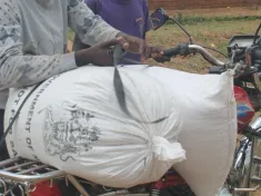 A beneficiary packing relief maize onto a motorcycle in Blantyre