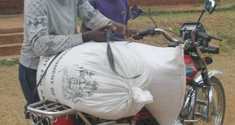 A beneficiary packing relief maize onto a motorcycle in Blantyre