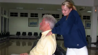 Bill Clinton lies back in a chair as he receives a neck massage from a former victim of Jeffrey Epstein. MEGA