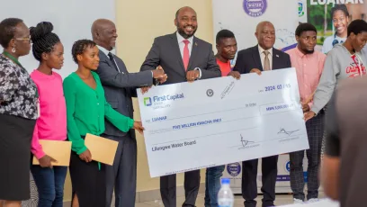 Chairperson of the Lilongwe Water Board, Inkosi Mbelwa IV presenting cheques to LUANAR's Chair of Council, Professor Zachary Kasomekera and students