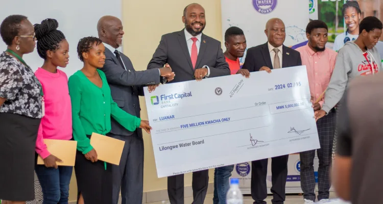 Chairperson of the Lilongwe Water Board, Inkosi Mbelwa IV presenting cheques to LUANAR's Chair of Council, Professor Zachary Kasomekera and students