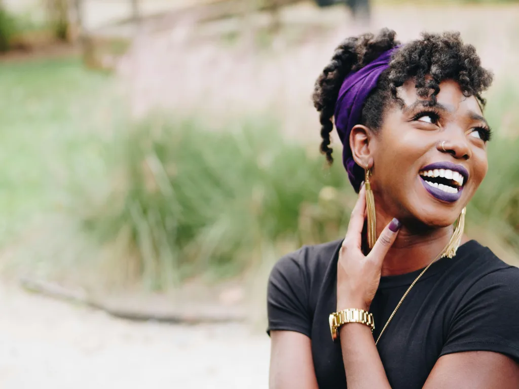 Smiling woman with purple lipstick.