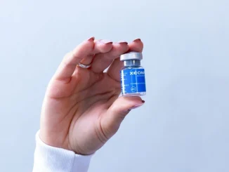 close up of hand holding cosmetic injection vial
