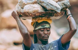 laborer carrying heavy rocks outdoors