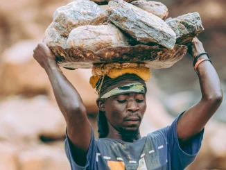 laborer carrying heavy rocks outdoors