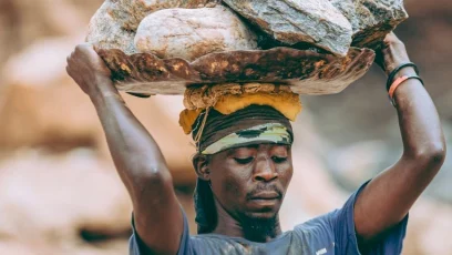 laborer carrying heavy rocks outdoors