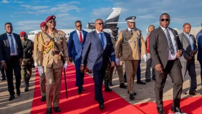 Malawi President Peter Mutharika walks along a red carpet alongside senior military, police and security officials during an airport arrival ceremony